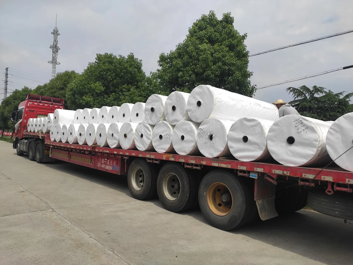 Bulk white woven fabric rolls loaded on a truck for dispatch reference