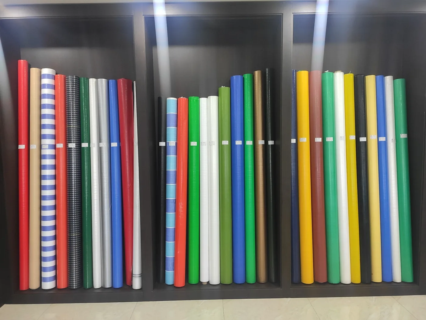 Multiple colored woven fabric roll options displayed for buyer reference