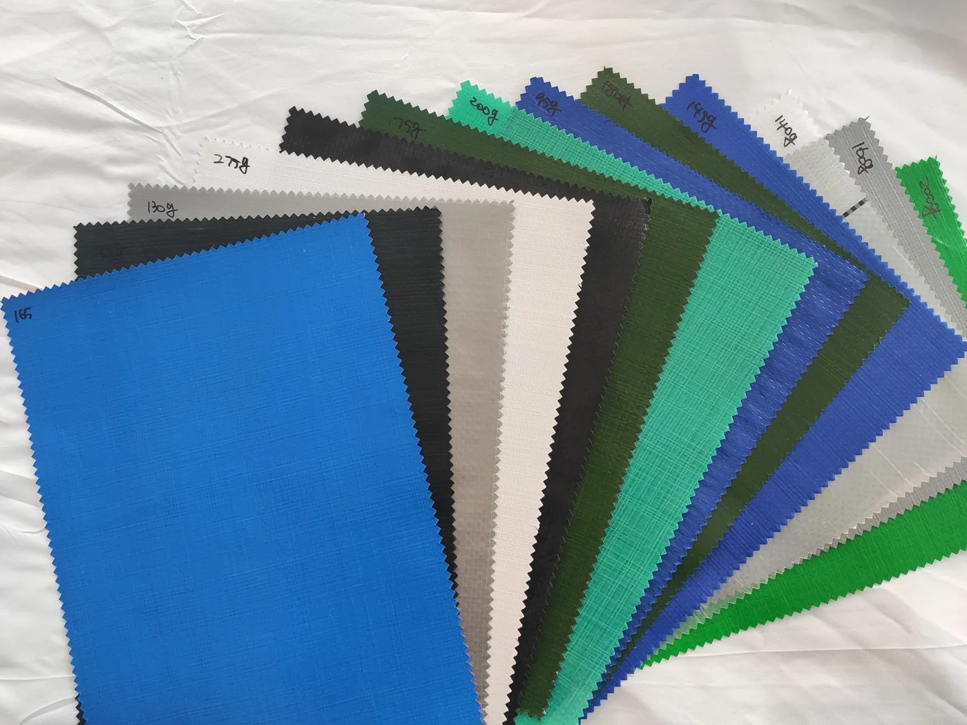 Woven fabric sample swatches in multiple colors and weights for specification discussion